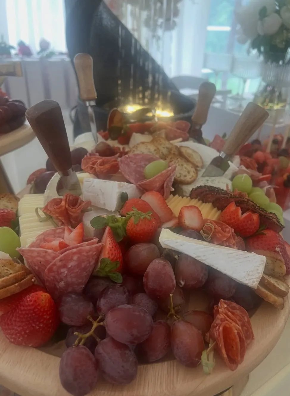 04-charcuterie-board.jpg Charcuterie board with salami roses, brie, cheddar, crackers, strawberries and grapes