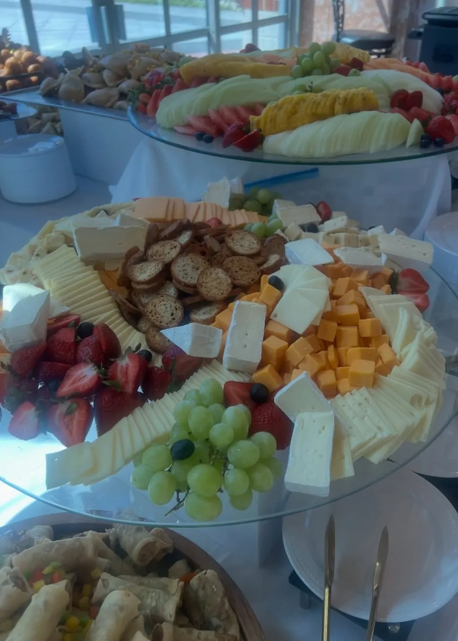 06-cheese-and-fruit-buffet.jpg Buffet with a tiered cheese and fruit display, pastries behind and spring rolls in front